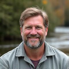 Headshot of Mike Thompson, a rugged and approachable outdoor equipment specialist, smiling confidently.